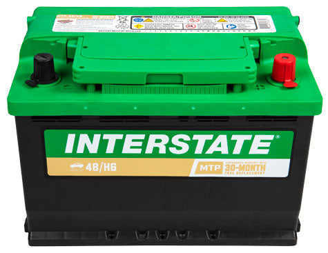 Car battery with Interstate label on front, green top black case