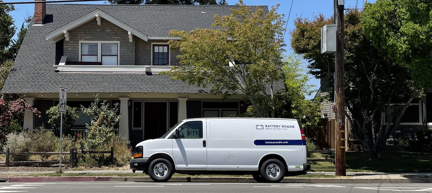 Battery Roadie van parked in front of large home
