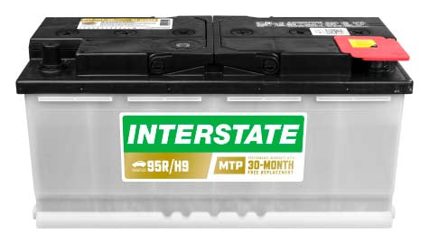 Long car battery, white case with black top.  Recessed termianls, Interstate label.